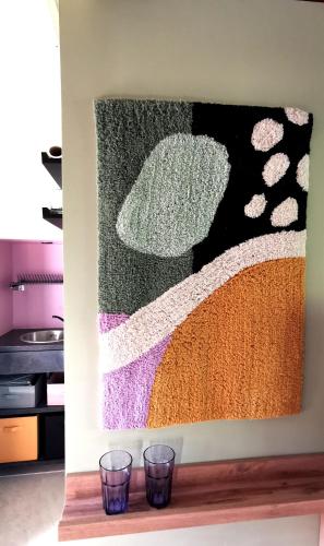 un tableau sur un mur avec deux verres sur une étagère dans l'établissement Un nid d'amour, à La Celle-sous-Gouzon