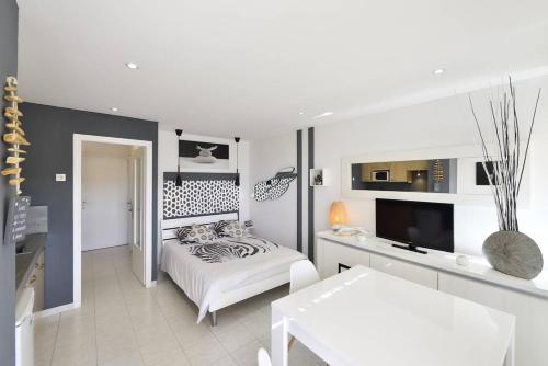 une chambre blanche avec un lit et une table dans l'établissement Studio Glossy Héliopolis AB 325 - 2 personnes, au Cap d'Agde