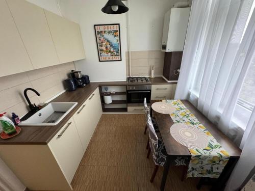 una piccola cucina con un tavolo e un lavandino di Clock House a Bucarest