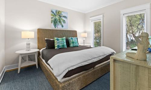 a bedroom with a large bed and two windows at Inlet Breeze in Inlet Beach