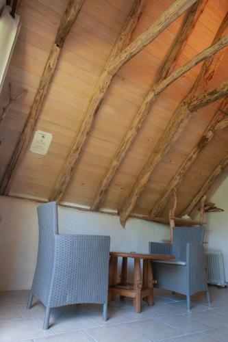 un plafond en bois avec deux chaises et une table dans l'établissement la métairie haute, à Marcilhac-sur-Célé