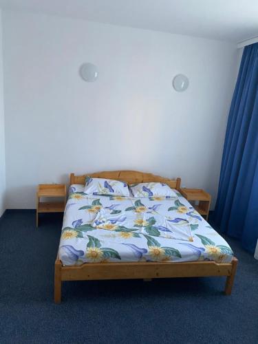 a bedroom with a bed with a floral bedspread at Casa cu flori in Văleni