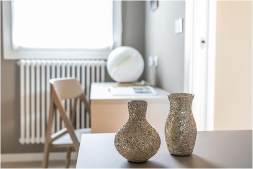 two vases sitting on a table in a room at Tiffany Silver in Burano