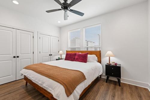 ein Schlafzimmer mit einem Bett und einem Deckenventilator in der Unterkunft NEW Thibodeaux House Cajun Luxury 65 TV Fast WiFi in Lafayette