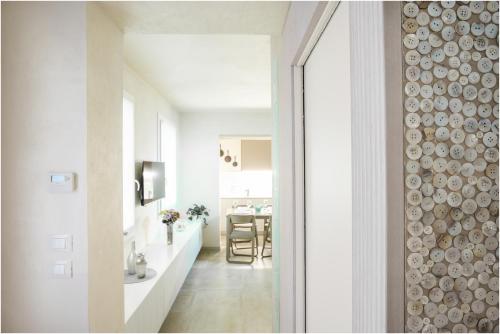 a white hallway with a dining room with a table at Tiffany Silver in Burano