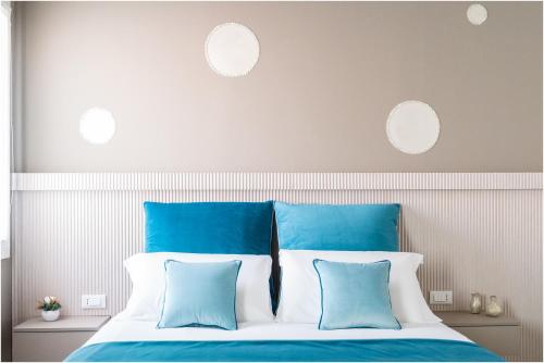 a bed with blue and white pillows in a bedroom at Tiffany Silver in Burano