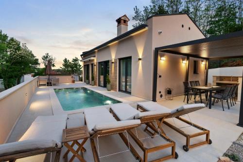 a patio with a swimming pool and a house at Charming Villa Harmonia with Heated pool and Indoor Jacuzzi surrounded by nature in Pićan