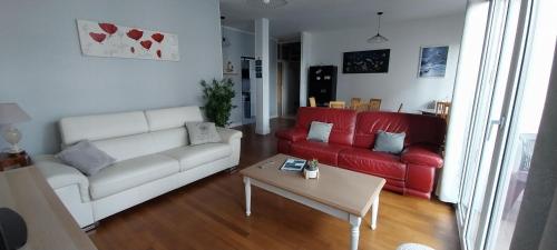 a living room with a white couch and red couches at Maison de ville plein centre, 3 étoiles, à 200m de la plage, parking privé, WIFI in Royan