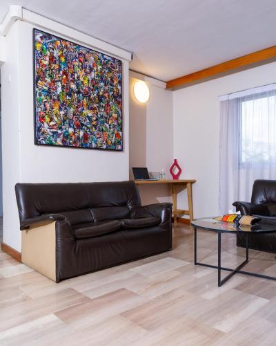 a living room with a couch and a painting on the wall at Résidences Les Hauts de l'Indenié in Abidjan