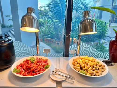 two bowls of food on a table with two lights at The AZURE Arena Cam Ranh Resort in Thôn Hò Ða