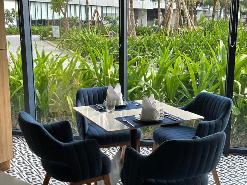 a table and chairs in front of a window at The AZURE Arena Cam Ranh Resort in Thôn Hò Ða