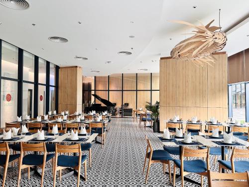a restaurant with tables and chairs and a piano at The AZURE Arena Cam Ranh Resort in Thôn Hò Ða