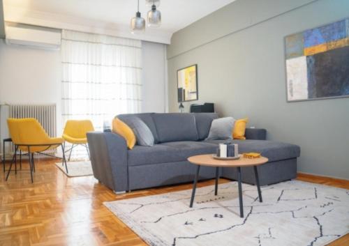 a living room with a blue couch and a table at Prime location - 2 bd Boutique apartment in Thessaloniki
