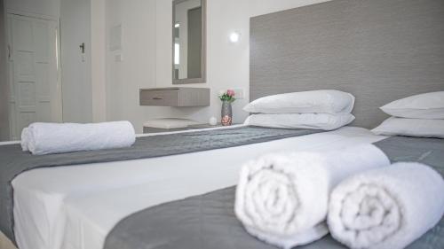 a large white bed with white towels on it at Windmills Hotel Apartments in Protaras