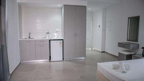 a kitchen with a sink and a white refrigerator at Windmills Hotel Apartments in Protaras