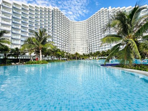 a large swimming pool in front of a large building at The AZURE Arena Cam Ranh Resort in Thôn Hò Ða