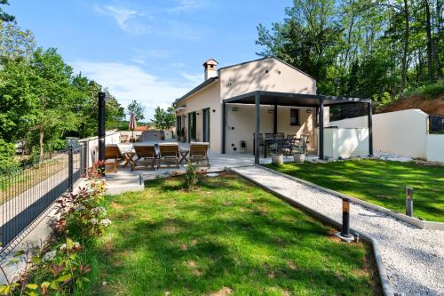a home with a covered patio and grass at Charming Villa Harmonia with Heated pool and Indoor Jacuzzi surrounded by nature in Pićan