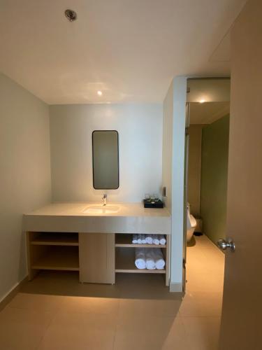 a bathroom with a sink and a tv on the wall at The AZURE Arena Cam Ranh Resort in Thôn Hò Ða