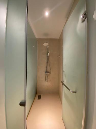 a bathroom with a shower and a walk in shower at The AZURE Arena Cam Ranh Resort in Thôn Hò Ða