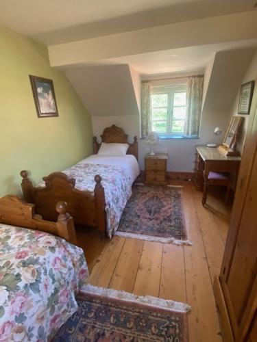 a bedroom with two beds and a table and a window at Beech Farm cottages in Tetney