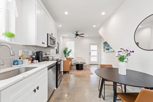 cocina con armarios blancos, mesa y comedor en NEW Couyon House Luxury Amenities Fast WiFi 65 TV, en Lafayette