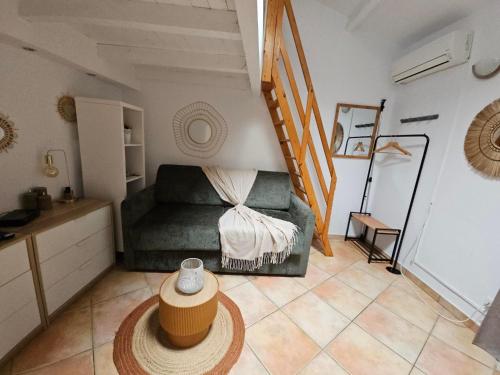 - un salon avec un canapé vert et un escalier dans l'établissement La Tiny House YourHostHelper, à Narbonne