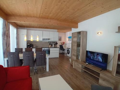 a living room with a red couch and a kitchen at Landhaus Almidyll in Seefeld in Tirol
