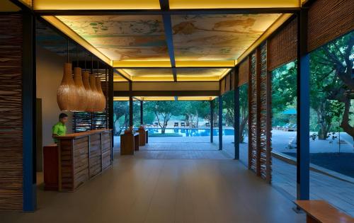 a lobby of a building with a person standing at a counter at Cinnamon Wild Yala in Yala
