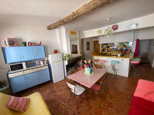 une cuisine avec une table et une cuisine avec des armoires bleues dans l'établissement Duplex coup de cœur assuré AUPS, à Aups