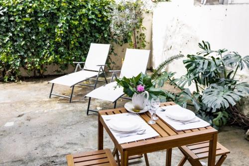 a wooden table with a vase of flowers on it at SUNNY PATIO Apartment in Lisbon