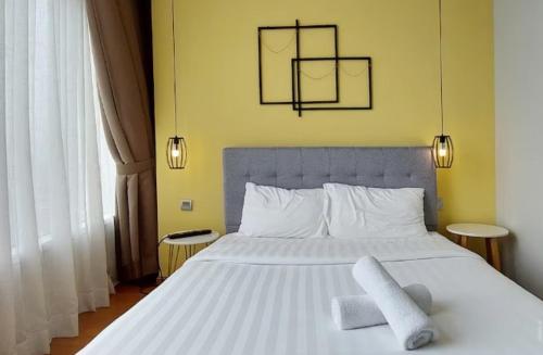 ein Schlafzimmer mit einem weißen Bett mit zwei Handtüchern darauf in der Unterkunft Private Room By Leisure Sky Suite KLCC in Kuala Lumpur