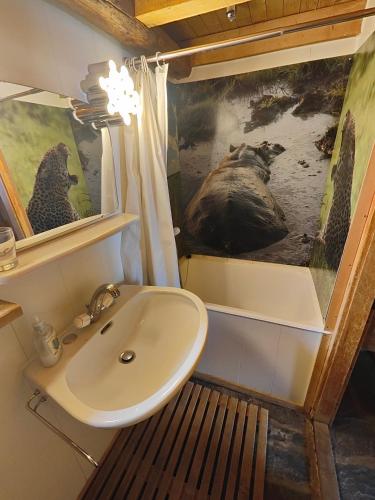 a bathroom with a sink and a picture of wolves at Mazot de l' Arche de Noé in Verbier
