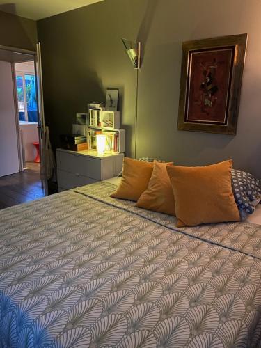 une chambre avec un grand lit avec des oreillers dessus dans l'établissement Stade de France - Magnifique terrasse arborée, à Saint-Denis