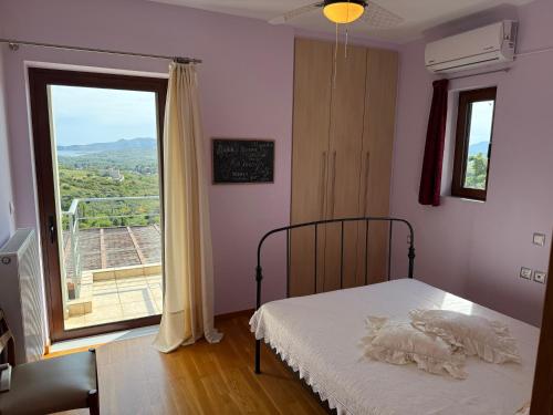 Un dormitorio con una cama y una ventana grande. en Villa Esperia, en Caristo