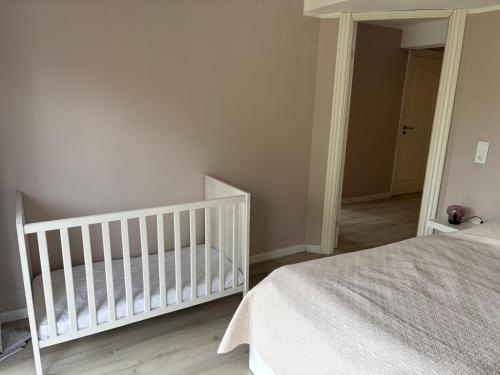 a white crib in a room with a bedroom at Augustenhof Ferien in Nordborg