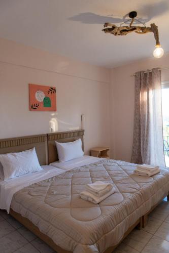a bedroom with a large bed with two towels on it at Sea and mountain hotel in Perdika