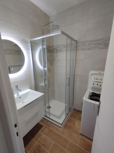 une salle de bain avec une douche en verre et un lavabo dans l'établissement Studio Proche Cure Rochefort, à Rochefort