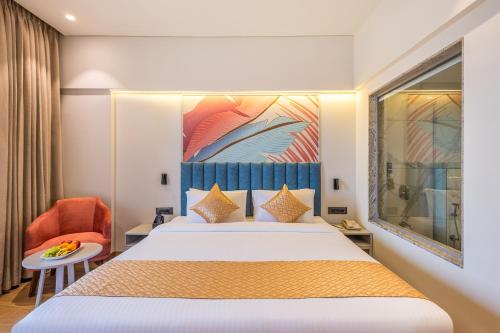 a hotel room with a bed and a chair at Effotel by Sayaji Navi Mumbai in Navi Mumbai