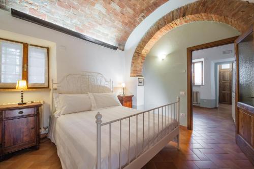 a bedroom with a bed and a brick wall at L'orto Delle Terme in Bagno Vignoni