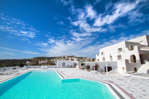 a large swimming pool in front of a white building at The Fisherman's House Santorini in Akrotiri