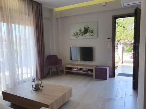a living room with a television and a table at Villa Modern Nikiti in Nikiti