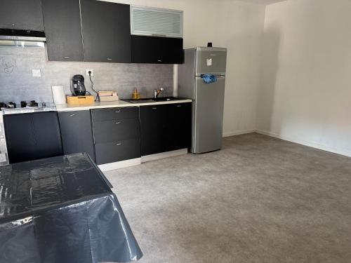 an empty kitchen with a refrigerator in a room at Appartement vacances in Benfeld