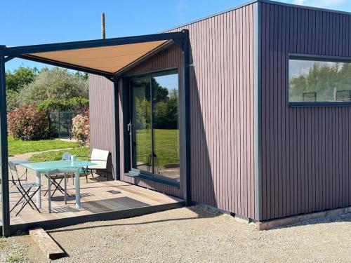 un petit hangar avec une table et une tente dans l'établissement Studio de jardin neuf, à Étoile-sur-Rhône