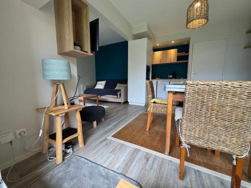 un salon avec une table et des chaises dans l'établissement Les Mules - Wifi, Parking, Piscine, Central, à La Baule