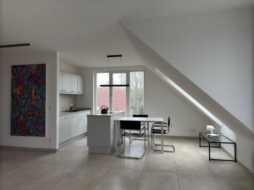 a kitchen with a table and chairs in a house at FeWo Clara - Ferienhaus Hiddensee in Kloster
