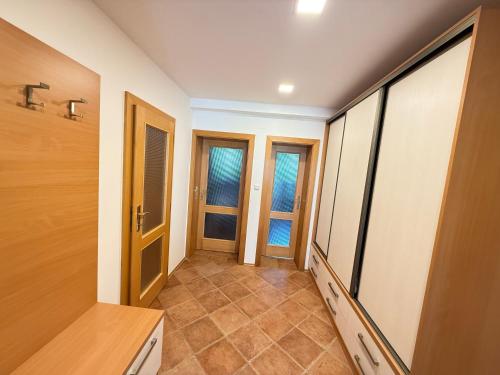 a hallway with two doors and tiled floors in a house at Na Pálavě na pohodu in Pavlov