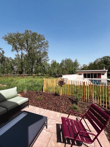 a patio with a couch and chairs and a fence at Grange ALMA in Obernai