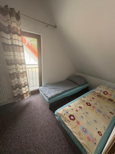 PozezdrzeDomki na Mazurach -Pieczarki的有两张床和一扇窗户的卧室