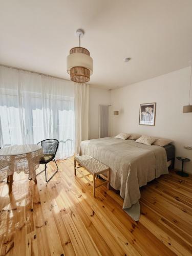 a bedroom with a bed and a table in it at powiew - adults only b&b pensjonat noclegi Świnoujście - Unterkunft Swinemünde - guesthouse tennis garden breakfast at baltic sea in Świnoujście