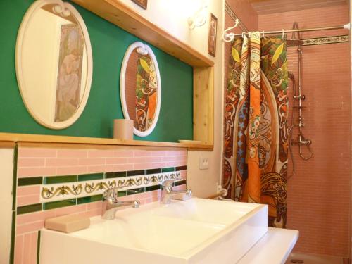 Un baño con un lavabo y dos espejos en la pared. en Mas Del Vracou, en Bollène